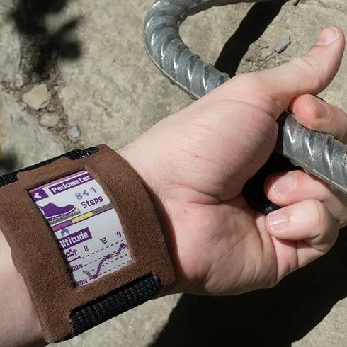 The photo shows the wearable ePaper prototype during a hiking tour. Specifically, the step count and altitude statics are shown on the wearble display.